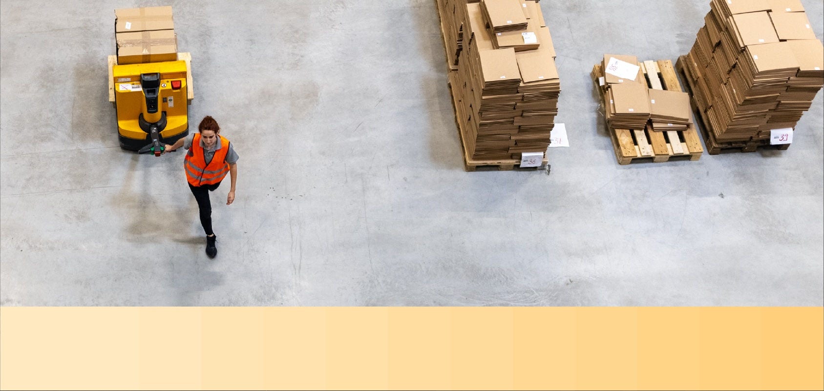 Aerial view of a warehouse employee moving packages on a pallet